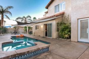 une maison avec une piscine devant une maison dans l'établissement Desert Escape, à La Quinta