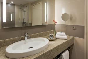 a bathroom with a sink and a mirror at Mercure Paris Orly Rungis Aéroport in Rungis