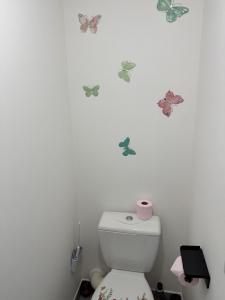a bathroom with butterflies on the wall above a toilet at Beau T2 Arlesien in Arles +7 photos