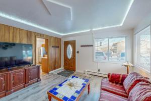 a living room with a couch and a flat screen tv at Red Deck Retreat in Anchorage