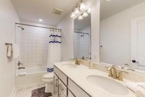 a white bathroom with two sinks and a toilet at Tower Shores - Sunshine Daydream --- 39546 Admiral Road in Bethany Beach +19 photos