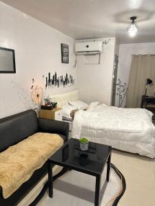 a living room with two beds and a couch at Affordable Condo in Cebu in Cebu City