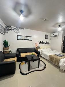 a living room with a couch and a bed and a table at Affordable Condo in Cebu in Cebu City