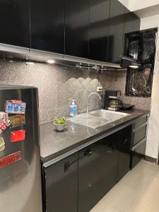 a kitchen with a sink and a refrigerator at Affordable Condo in Cebu in Cebu City