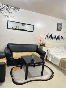 a living room with a black couch and a table at Affordable Condo in Cebu in Cebu City +2 photos