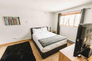 ein Schlafzimmer mit einem Bett und einem Flachbildfernseher in der Unterkunft Sunday River Ski In Ski Out Mountain View Condo with Hot Tub Pool and Sauna! in Newry + 19 Fotos