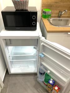 een open koelkast met een magnetron in een keuken bij Alle porte del Castello 23 in Catania