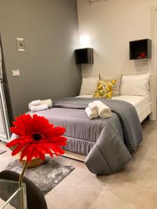 een slaapkamer met een groot bed met een rode bloem bij Alle porte del Castello 23 in Catania
