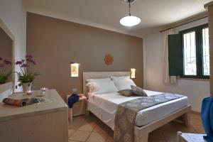 Un dormitorio con una cama y una mesa. en Masseria Tenuta Specolizzi, en Lido Marini