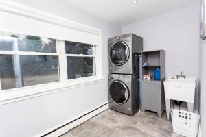 a laundry room with a washer and dryer next to a window at Cozy 3BR Home with Parking, Backyard and Near Transit in Toronto