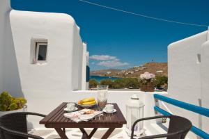 a table on a balcony with a view of the ocean at Gelos House in Ornos