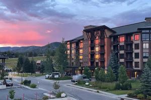 a building with a parking lot in front of it at Steps to Gondola – Elevate Townhome at Wildhorse Meadows in Steamboat Springs
