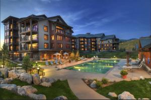 a large apartment building with a swimming pool at Steps to Gondola – Elevate Townhome at Wildhorse Meadows in Steamboat Springs