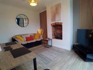 a living room with a couch and a fireplace at Enchanting 4 spacious bedrooms in Birmingham