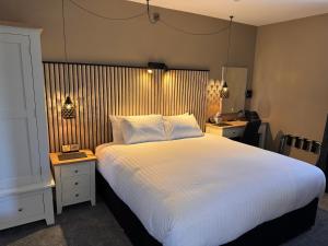 a bedroom with a large white bed and two night stands at South Lawn Hotel in Lymington