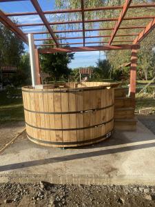 a large wooden barrel sitting under a roof at Cabañas Los Culenes in Colbún
