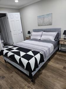 クリーブランドにあるThe Urban Oasisのベッドルーム1室(大型ベッド1台、白黒の掛け布団付)