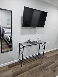 クリーブランドにあるThe Urban Oasisの壁にテレビが備わる客室で、ガラスのテーブルが付いています。