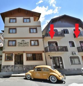 um carro amarelo estacionado em frente a um prédio em Stillo Gramado Aconchego com café da manhã em Gramado