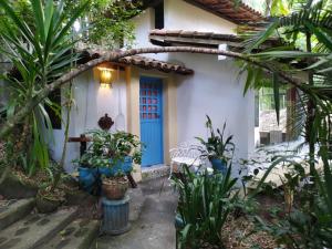 una casa con una porta blu e alcune piante di Cultura Mix Guest House a Arraial d'Ajuda
