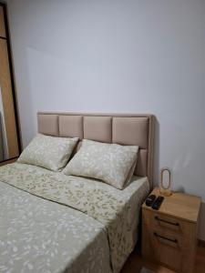 un letto con testiera e comodino accanto ad essa di Gala Lux Lazarevac a Lazarevac
