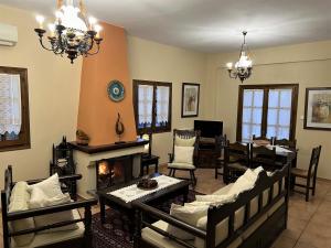 a living room with a dining table and a fireplace at Aroma Piliou - Άρωμα Πηλίου in Mouresi
