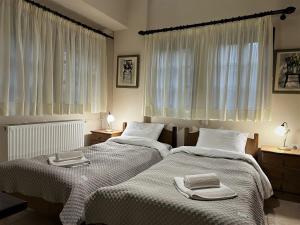 two beds in a bedroom with two towels on them at Aroma Piliou - Άρωμα Πηλίου in Mouresi