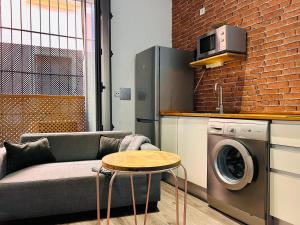 a living room with a couch and a washing machine at Estudio Casa Palacio 2Pax wifi gratis in Sanlúcar de Barrameda