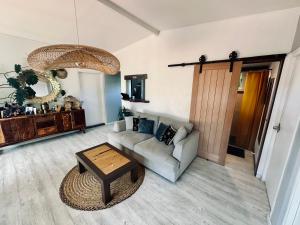 un soggiorno con un divano e un tavolo di Tropical Nest 2 a Faaa