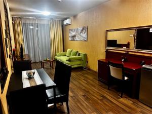 un soggiorno con un divano verde e un tavolo di Silver Marina Apartment-Őrzött mélygarázs a Balatonfüred