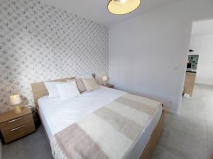 a bedroom with a large bed and a wall at Les Blés d'Or - Parking privé, Terrasse, Clim, Netflix, Au Calme in Hem-Lenglet