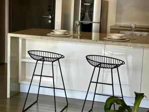 una cucina con due sgabelli neri da bancone di Loft estilo Japonés a Bogotá