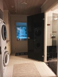 a laundry room with a washer and dryer next to a door at Winter Wonderland Home in Rovaniemi