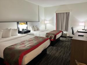 a hotel room with two beds and a desk at Ramada by Wyndham Sparta/At Speedway in Sparta +26 photos