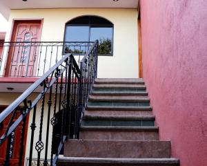 a staircase leading to a house with a pink wall at Departamento Bugambilia in Oaxaca City