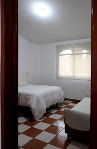 a bedroom with two beds and a window at Departamento Bugambilia in Oaxaca City