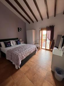 a bedroom with a large bed and a door to a patio at Casa Rural La Palmera in Cañada del Trigo
