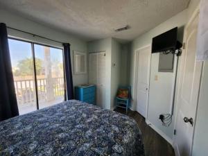 a bedroom with a bed and a large window at Across the Street from beach with 2 pools in Panama City Beach