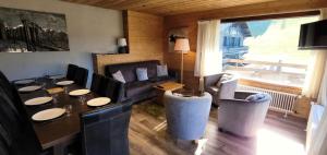 una sala de estar con una mesa, sillas y un sofá en Résidence Cry De Lys - Appartement entièrement rénové, au pied des pistes MAE-8451, en Les Gets