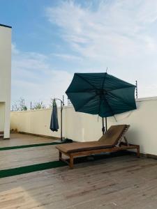a bench with an umbrella on a roof at 3 bedroom villa, off Harris Drive VGC Lagos in Lagos