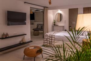 a bedroom with a bed and a tv on a wall at Noemia Skiathos in Skiathos