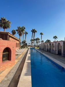 a swimming pool with palm trees next to a building at Mashrabiya hotel in Hurghada