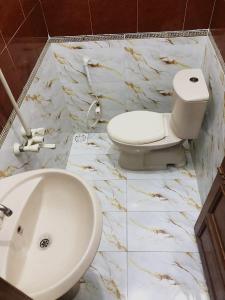 カラチにあるKarachi Airport Guest Houseの白いトイレと洗面台のあるバスルーム
