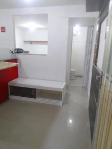 um banco branco num quarto com WC em Kitnet na praia da Macumba no morro do Rangel no Rio de Janeiro