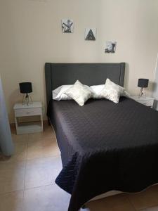 a bedroom with a black bed with two night stands at Talcahuano in Guaymallen