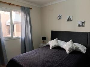 a bedroom with a bed with two pillows and a window at Talcahuano in Guaymallen