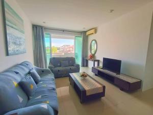 ミリにあるVI Homelite Resortのリビングルーム(青いソファ、テレビ付)