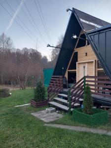 una piccola cabina con tetto nero e scale di legno di Cabana AFO A Frame a Brăteasca