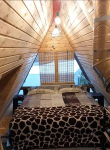 un letto grande in una stanza con soffitto in legno di Cabana AFO A Frame a Brăteasca