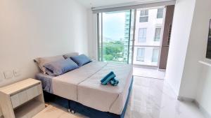 ein Bett in einem Zimmer mit einem großen Fenster in der Unterkunft PLAYA BELLO HORIZONTE "Encanto exclusivo a pasos del Mar" in Playa Bello Horizonte + 19 Fotos